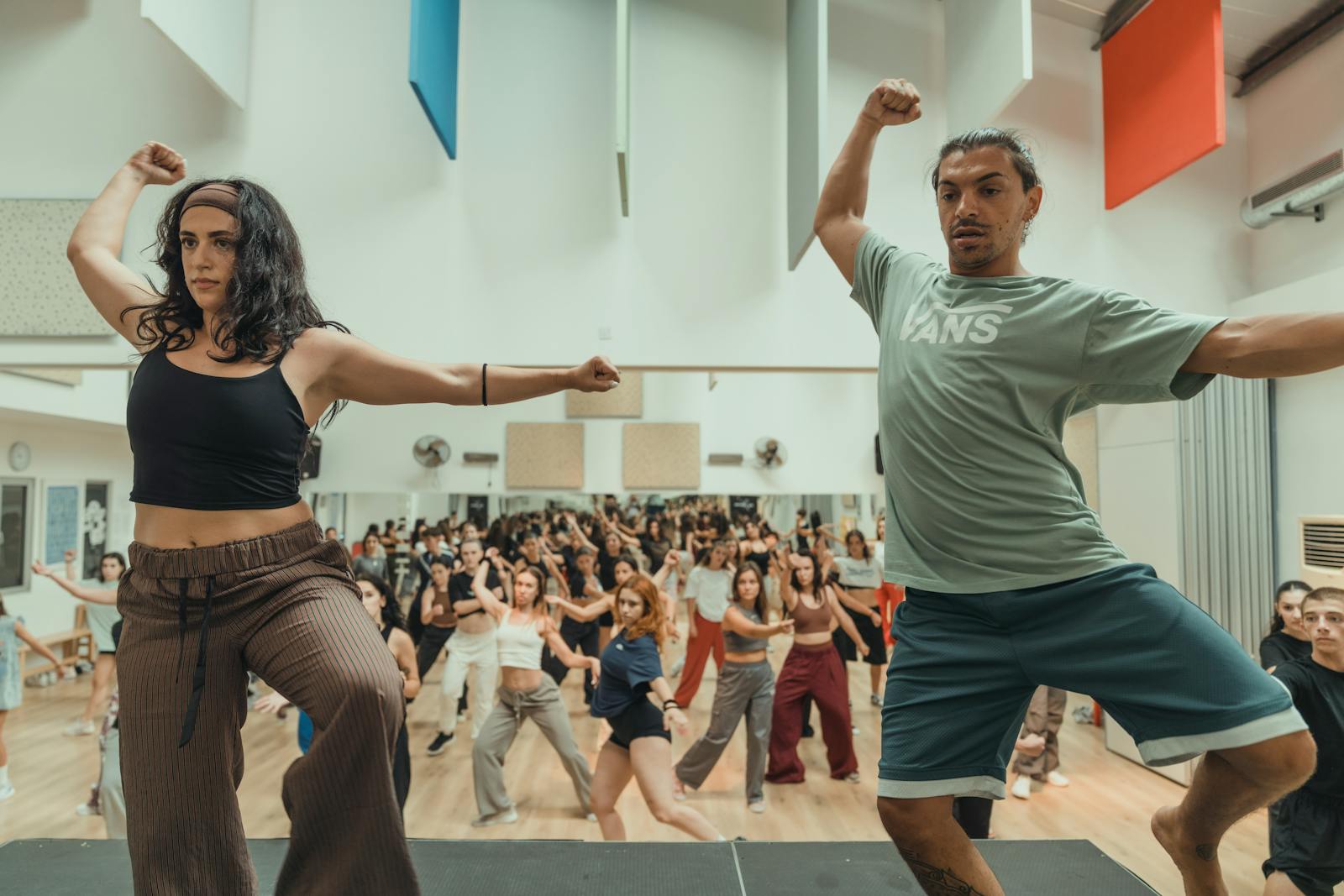 A vibrant indoor dance class featuring a group of energetic individuals practicing choreography.